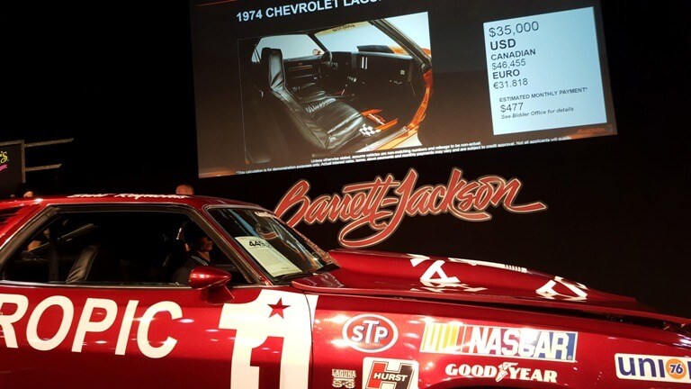 Video screen beside Barrett-Jackson Palm Beach auction block shows final bid on Burt Reynolds' Cannonball Run car at $35,000